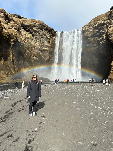 Hannah Cote in front of rainbow and waterfall.